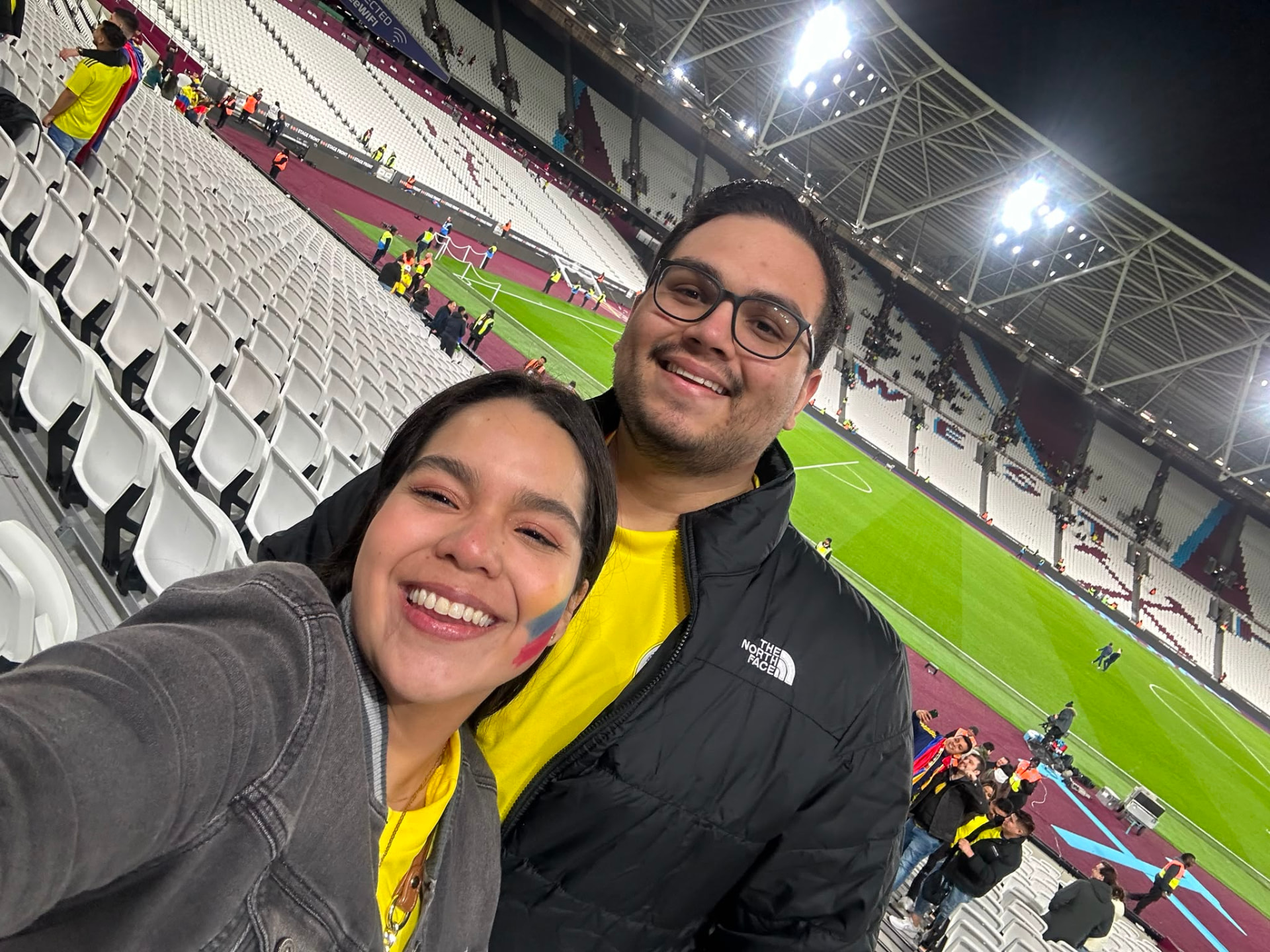 Majo y Juanpis en un estadio en Londres, con la camiseta amarilla de Colombia.